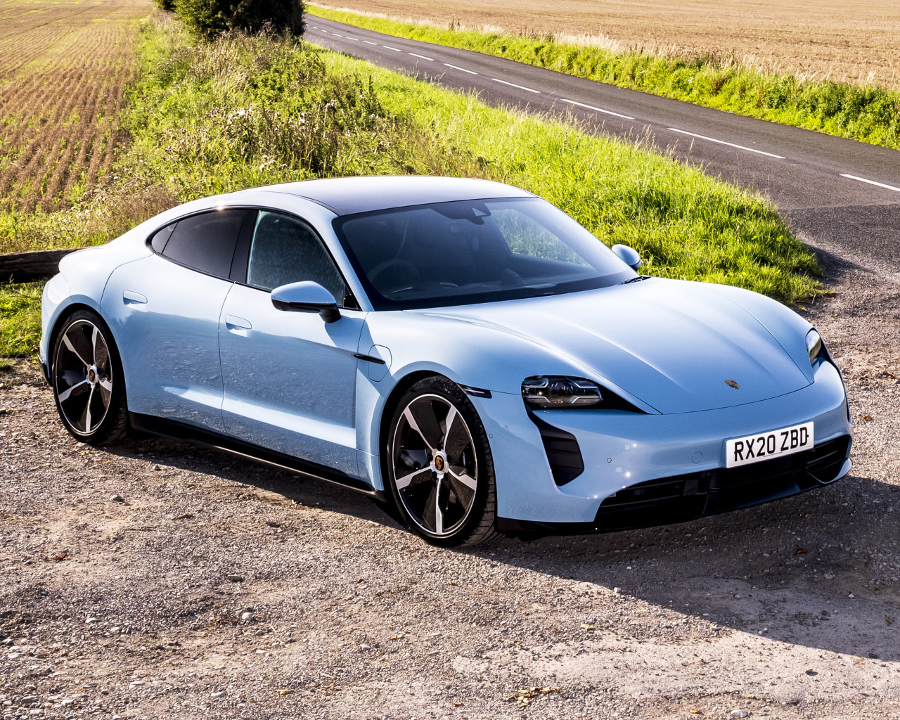 Быстрый автомобиль Porsche Taycan 4S 2021 года на фоне поля