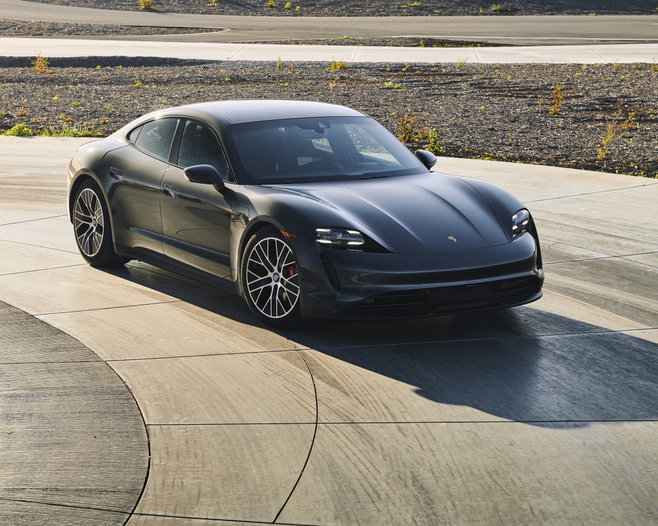 Черный автомобиль Porsche Taycan, 2020 года на дороге 