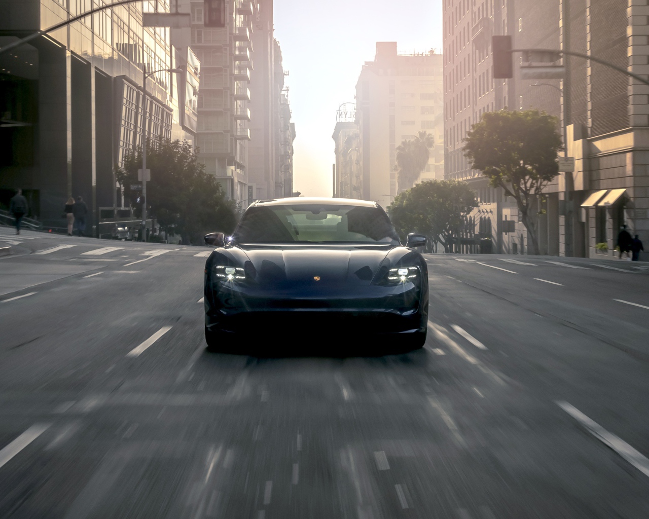 Черный стильный автомобиль  Porsche Taycan Turbo, 2020 года на дороге в городе