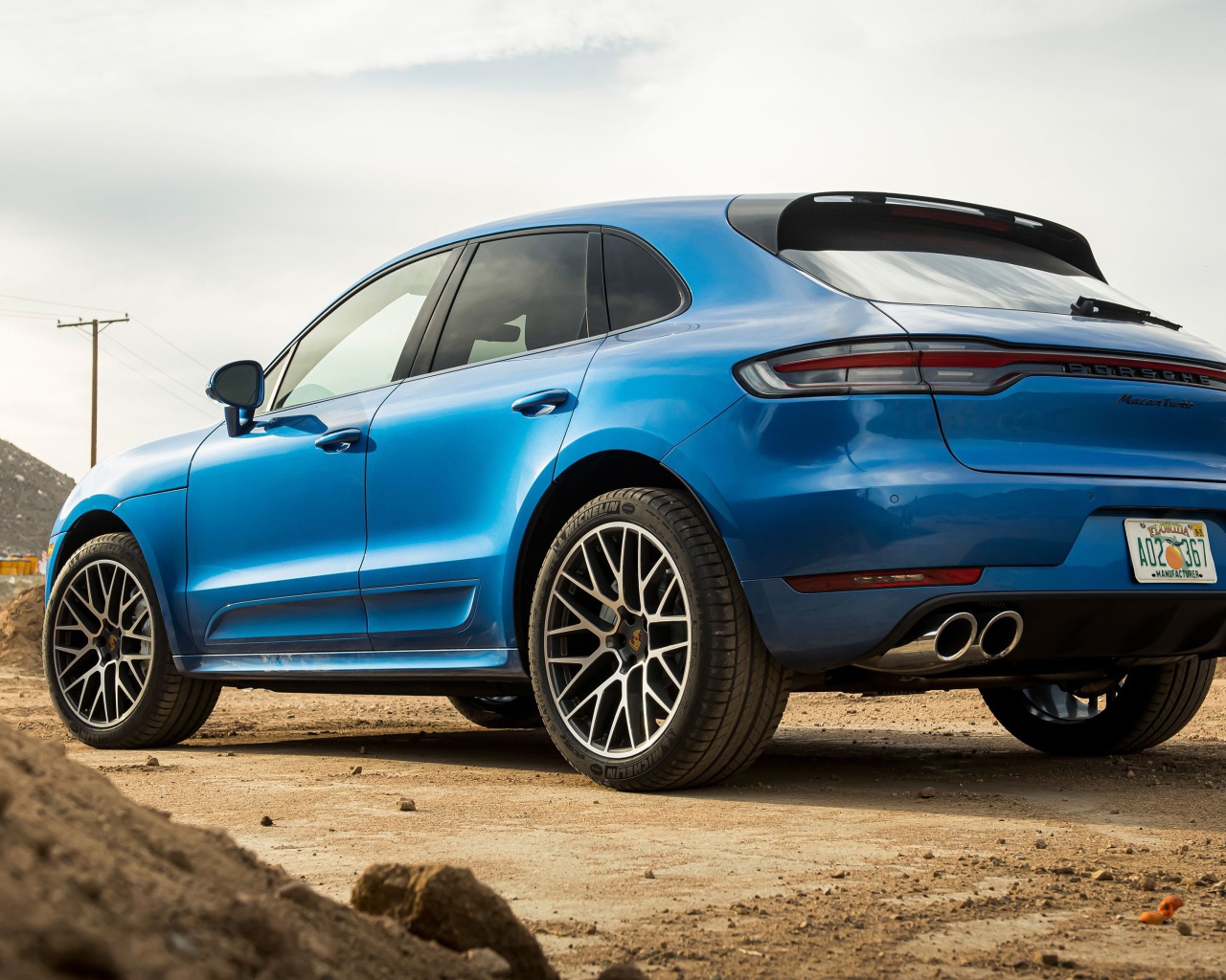 Синий автомобиль  Porsche Macan Turbo, 2020 года вид сзади 