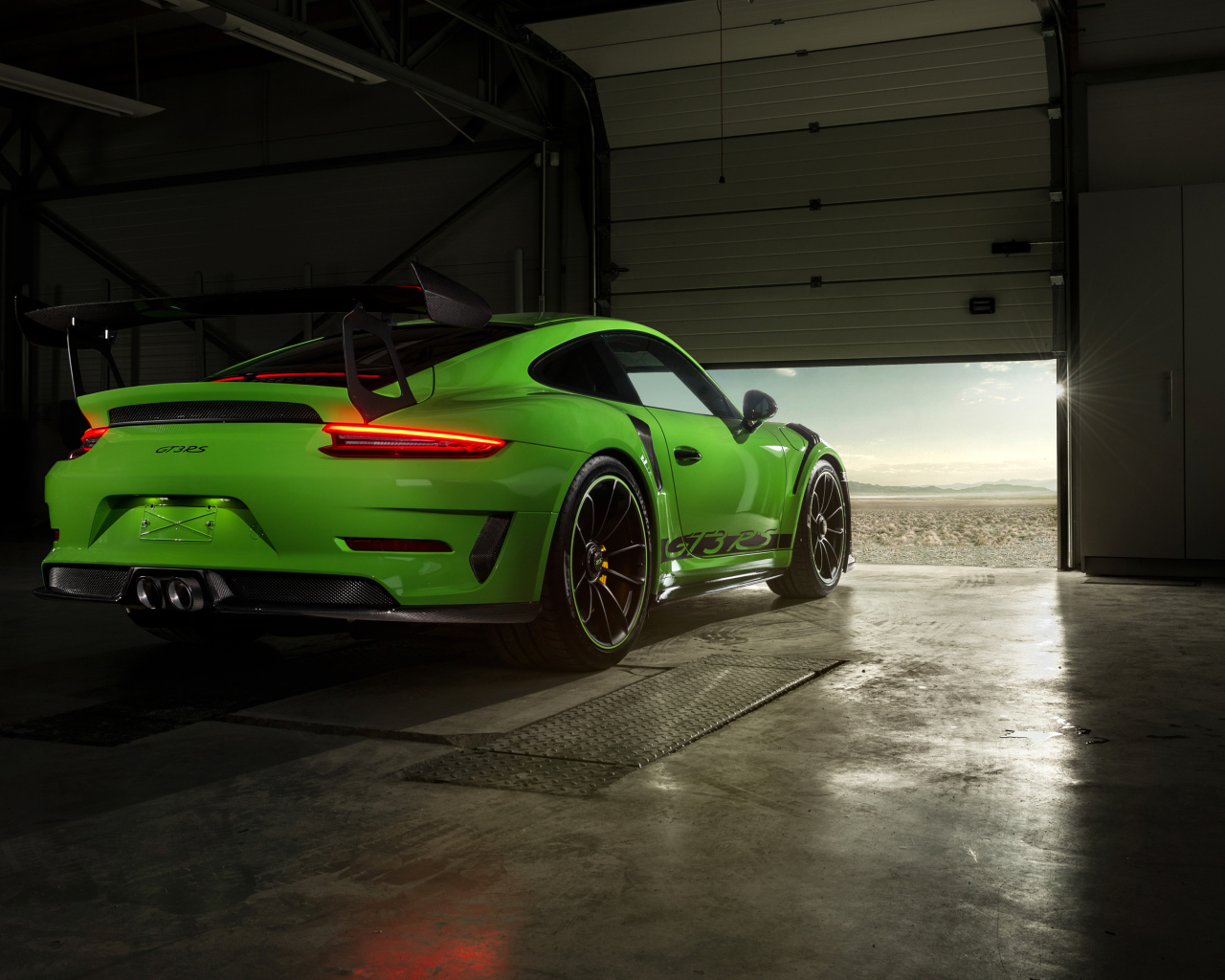 Зеленый автомобиль Porsche GT3 RS вид сзади