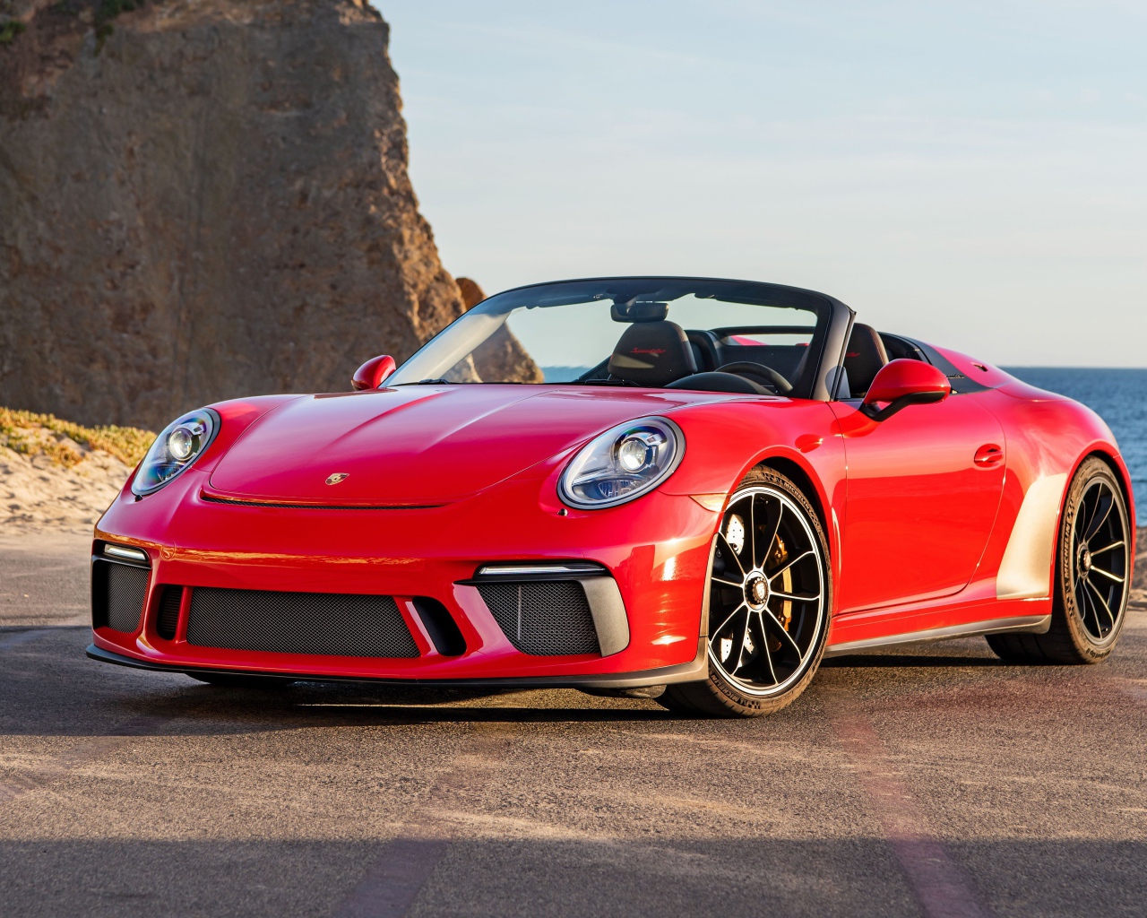 Красный автомобиль Porsche 911 Speedster, 2019 года у воды