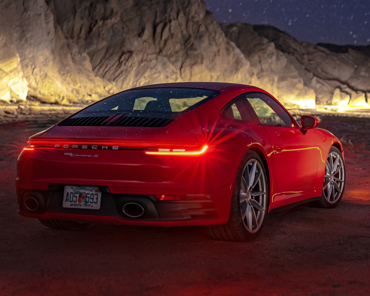 Красный автомобиль  Porsche 911 Carrera S, 2020 года в горах ночью 