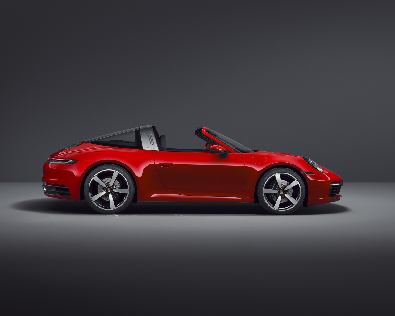 Красный кабриолет Porsche 911 Targa 4 2020 года на сером фоне