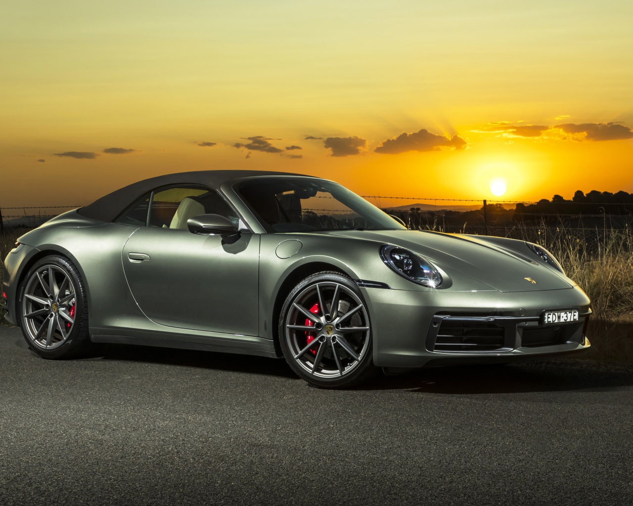 Серебристый Porsche 911 Carrera S Cabriolet 2020 года на закате 