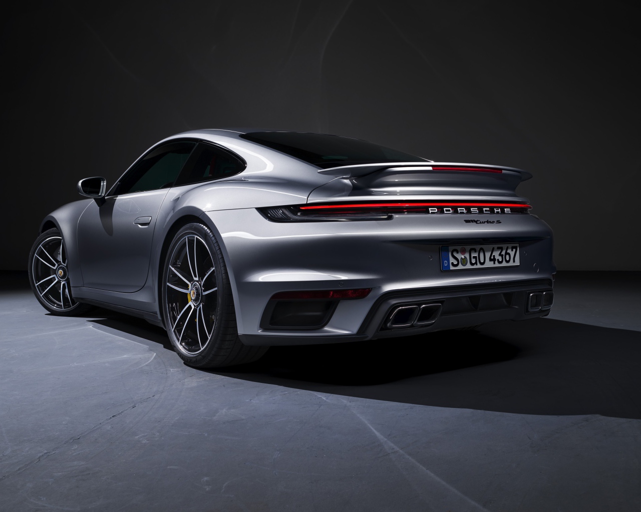Серебристый автомобиль Porsche 911 Turbo S 2020 года вид сзади
