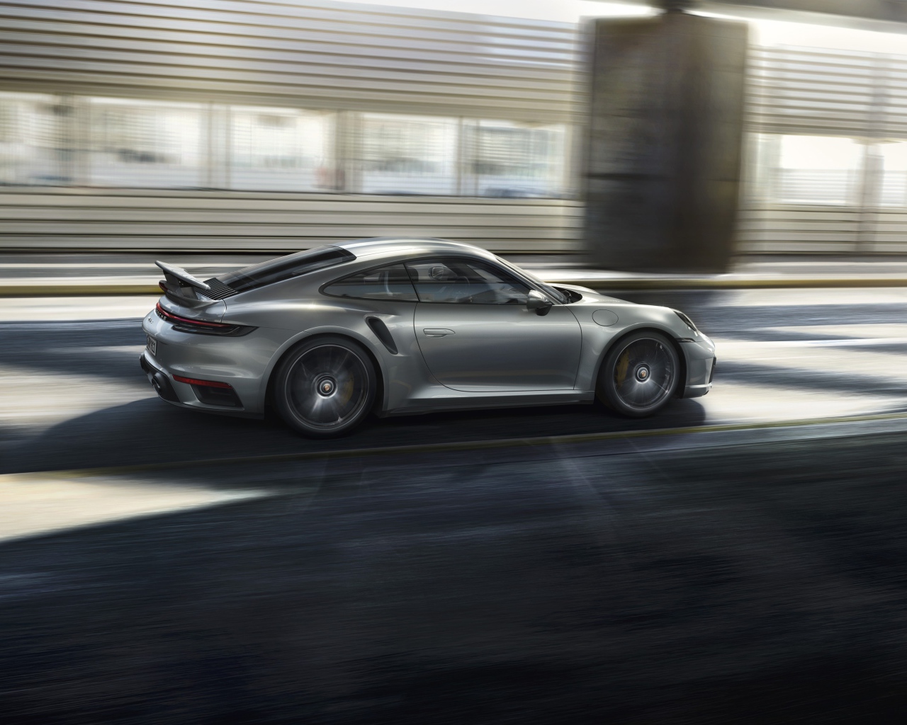 Серебристый автомобиль Porsche 911 Turbo S 2020 года на трассе 