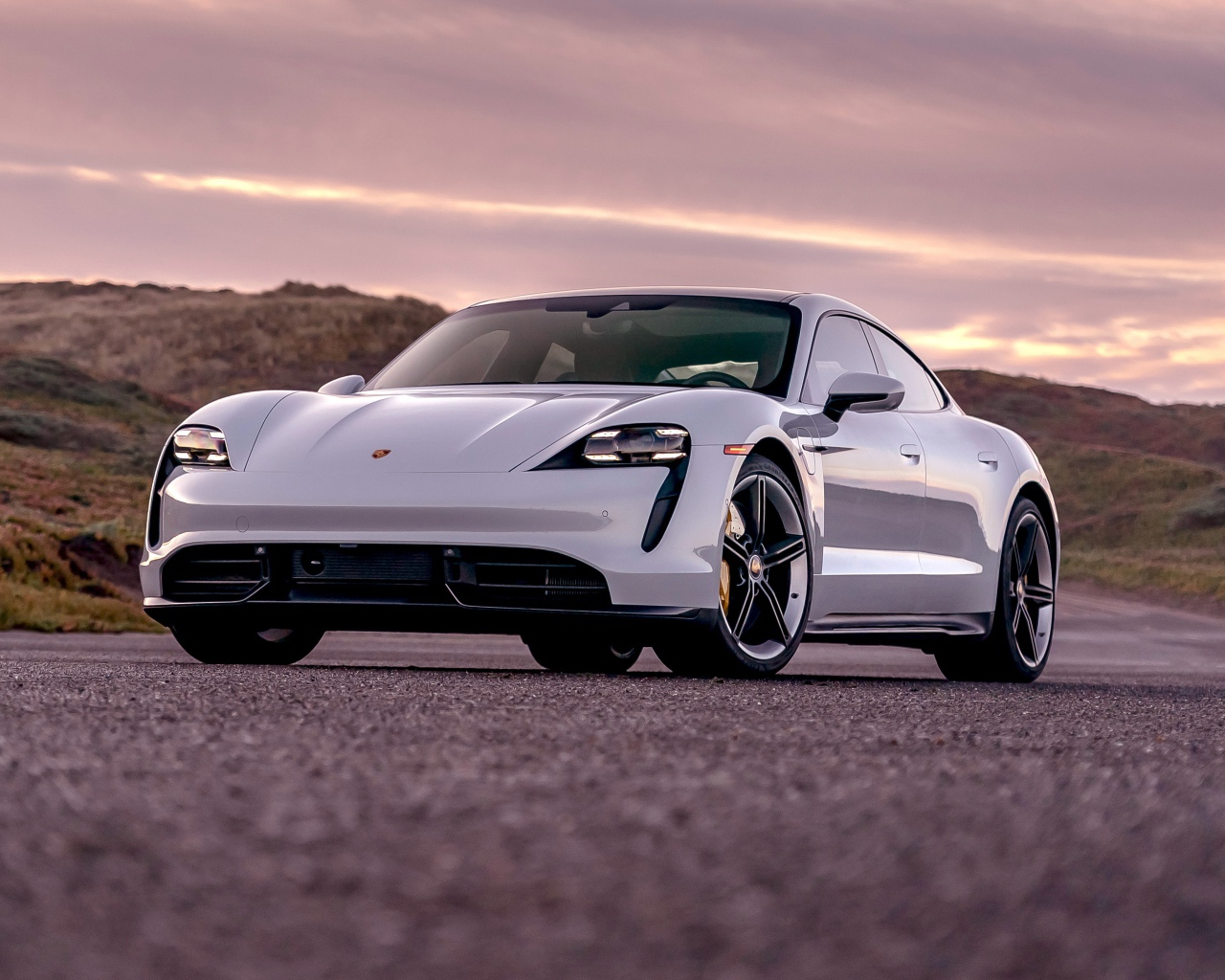 Серебристый автомобиль Porsche Taycan Turbo S 2020 года на фоне неба