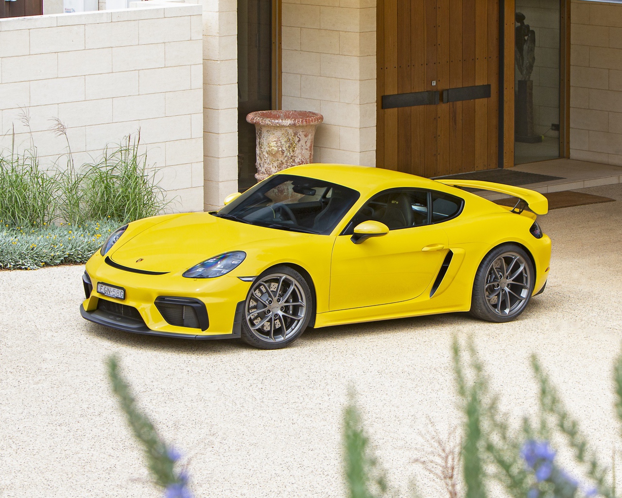 Желтый автомобиль Porsche 718 Cayman GT4,  2020 года