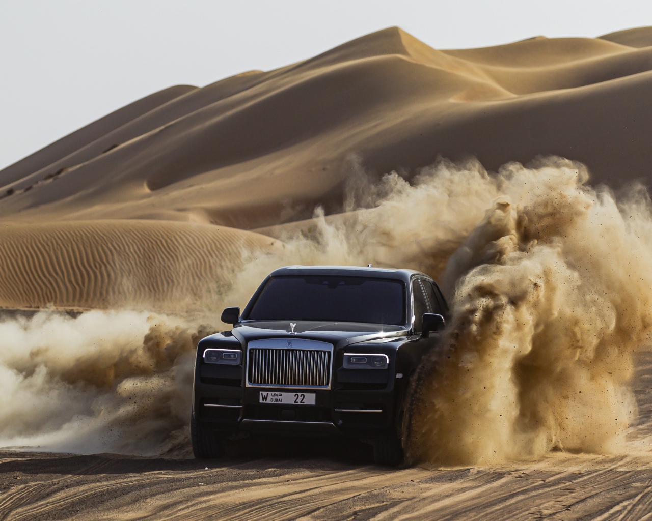Черный автомобиль Rolls-Royce Cullinan в пустыне