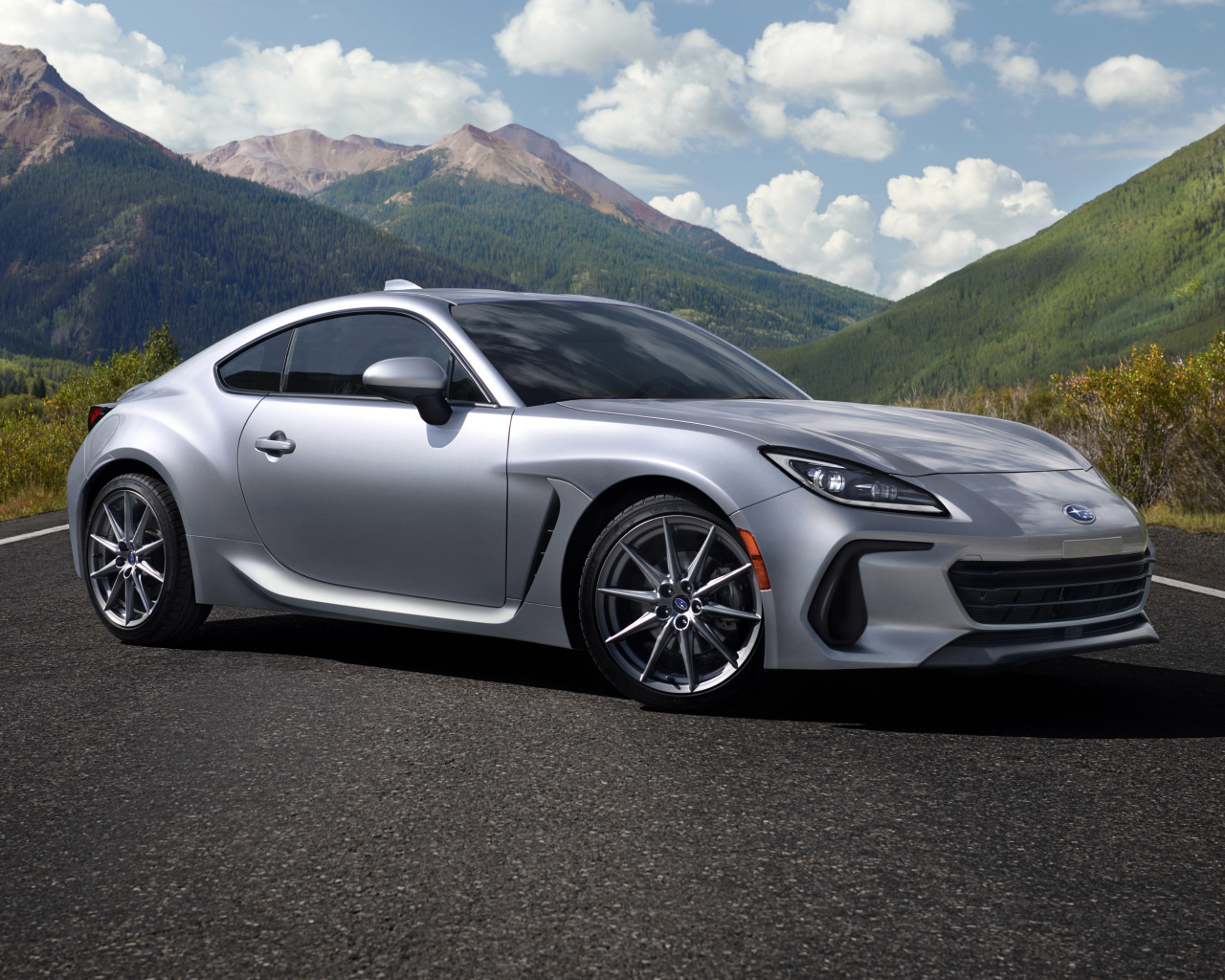 Серебристый автомобиль Subaru BRZ, 2022 года на фоне гор