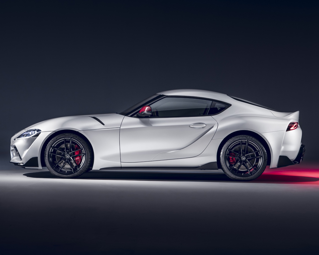 Серый автомобиль Toyota GR Supra 2L 2020 года вид сбоку на сером фоне
