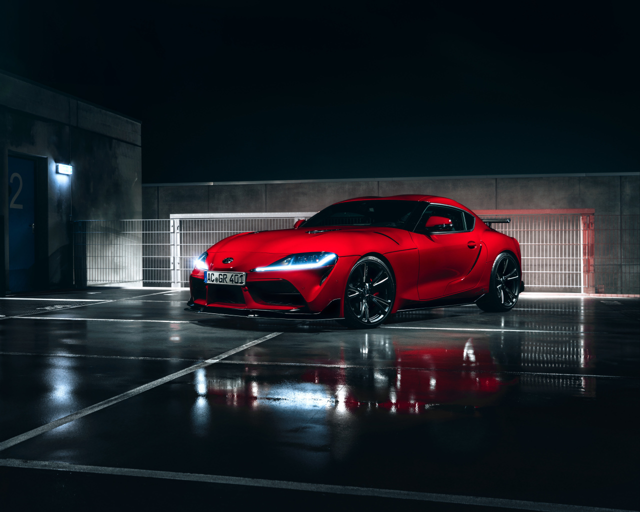 Красный автомобиль Toyota GR Supra AC Schnitzer 2019 года у гаража