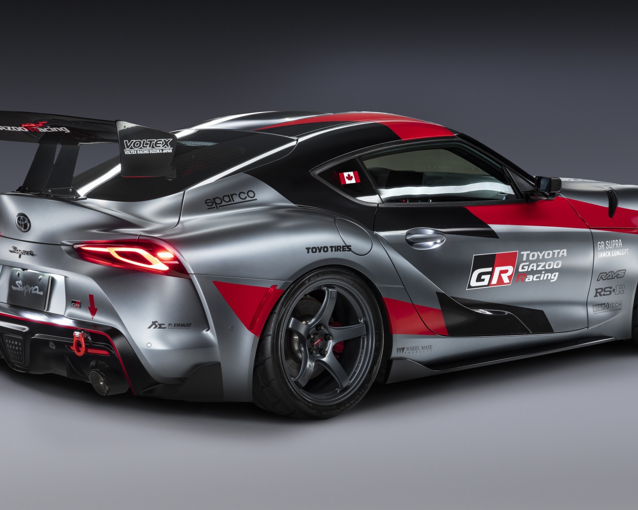 Спортивный автомобиль Toyota GR Supra Track Concept 2020 года вид сзади на сером фоне