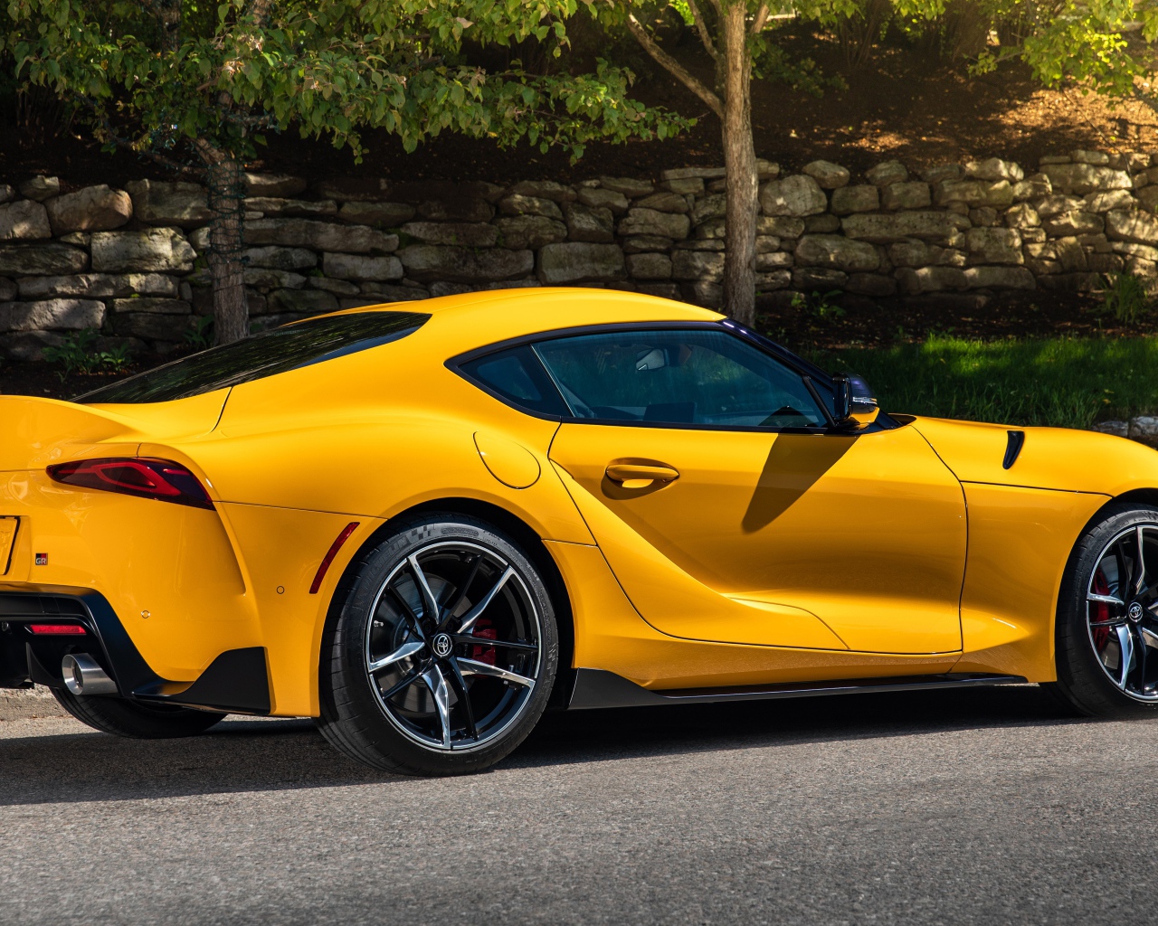 Желтый автомобиль Toyota GR Supra 2, 2021 года вид сбоку 