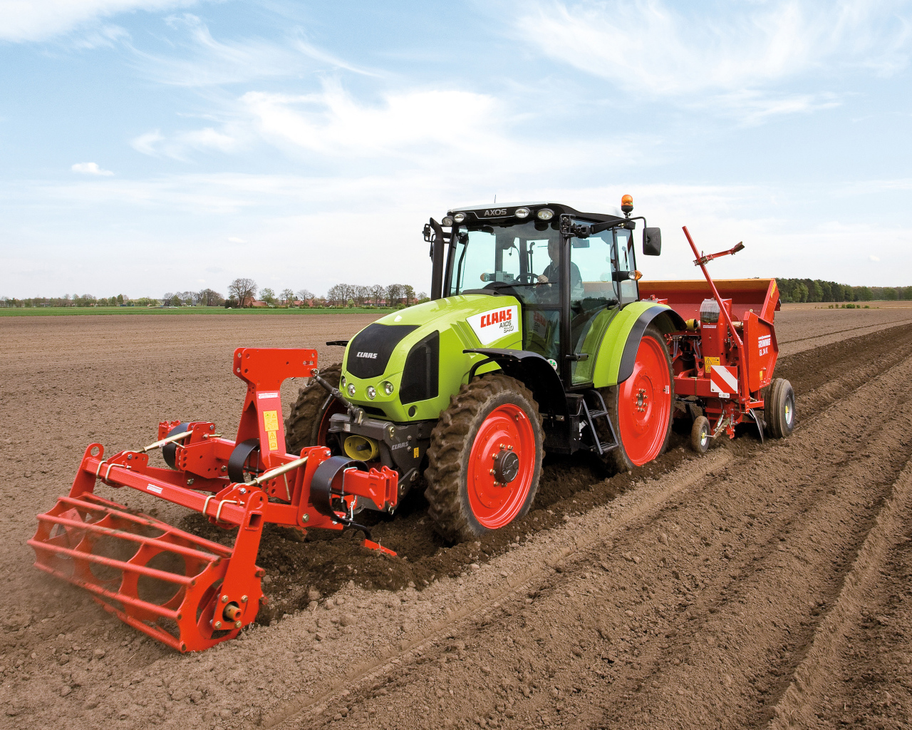 Большой комбайн сеет в поле 