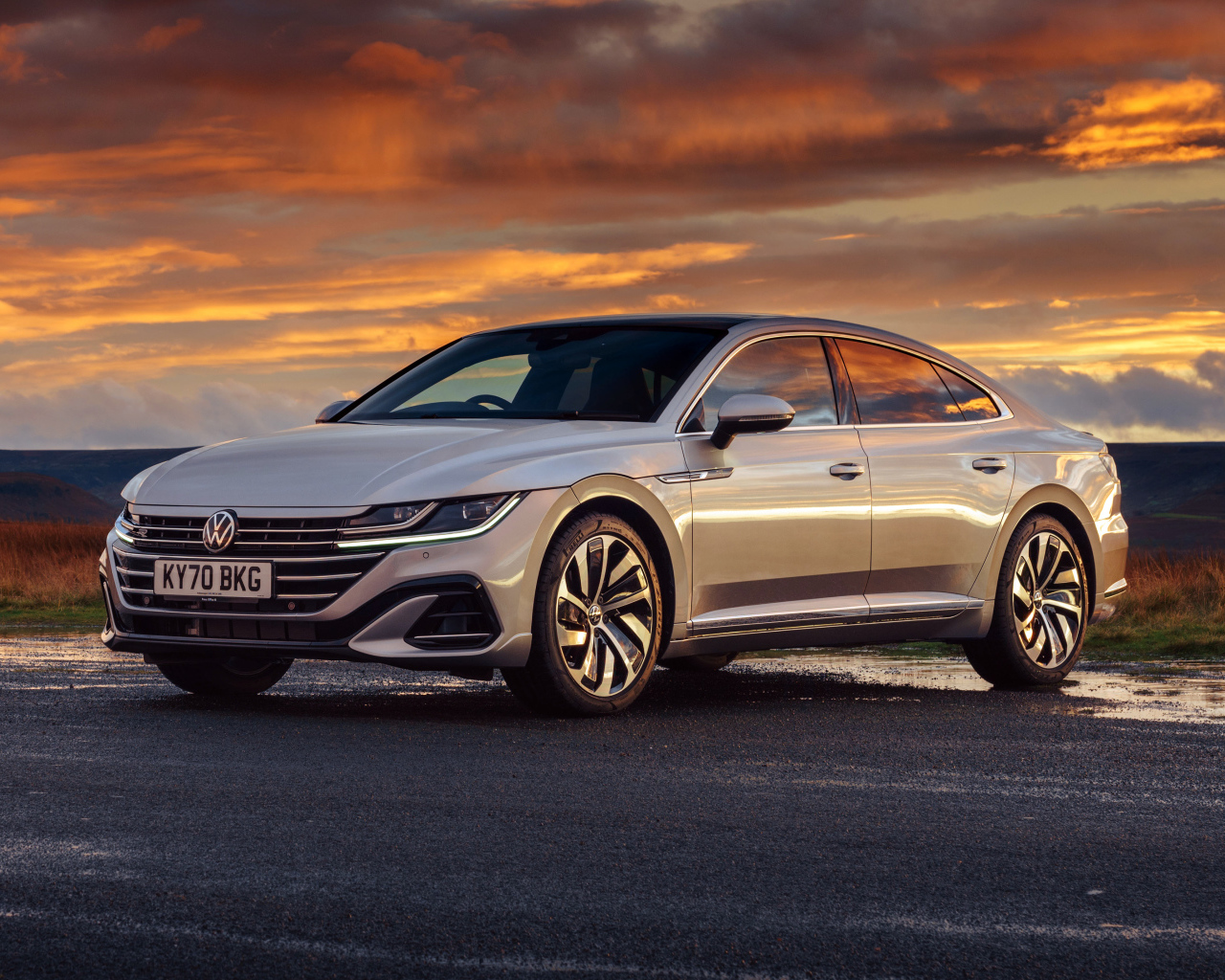 Серебристый автомобиль Volkswagen Arteon R-Line 2020 года на закате