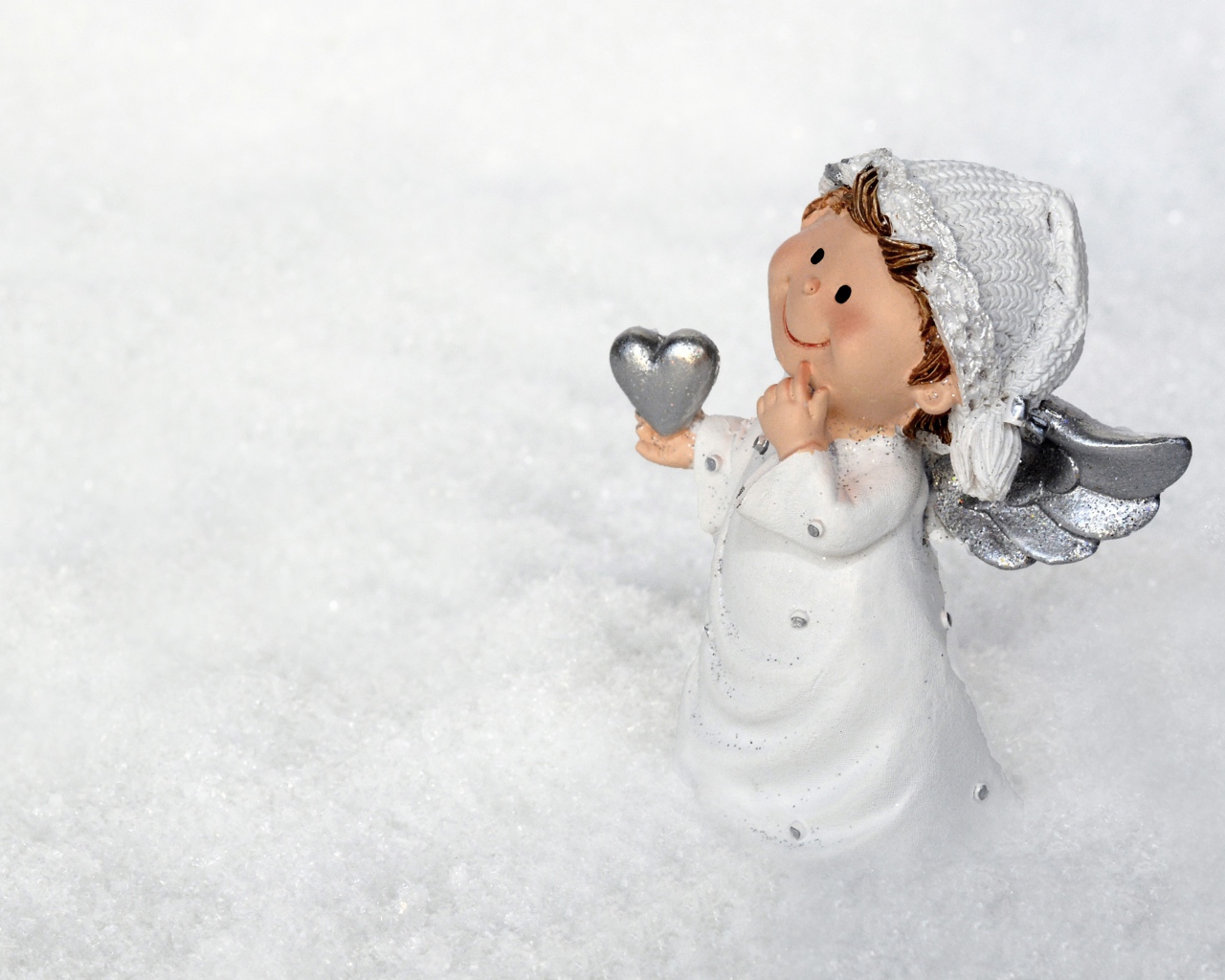 Статуэтка ангела стоит на снегу 