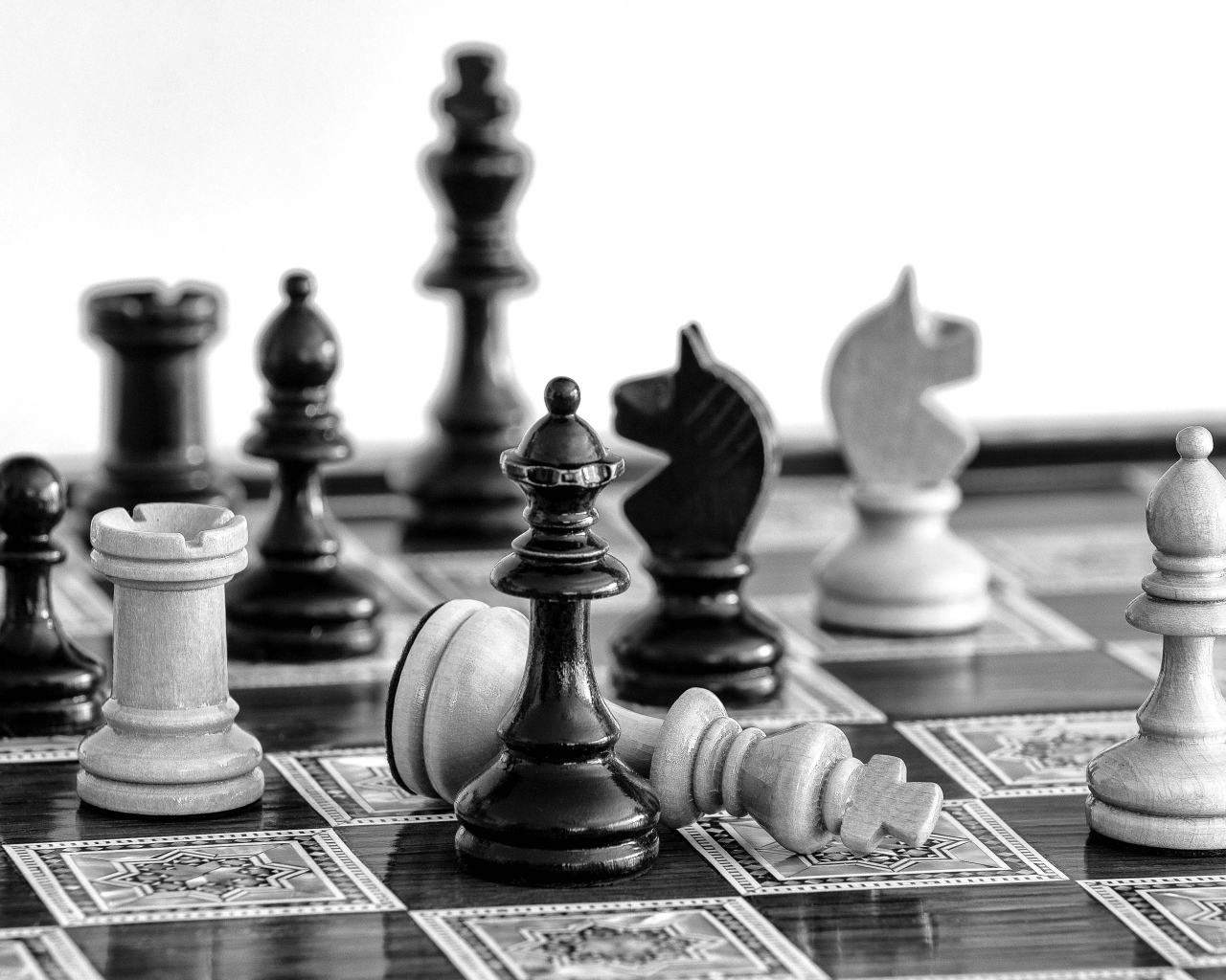 Черные и белые шахматные фигуры на доске 