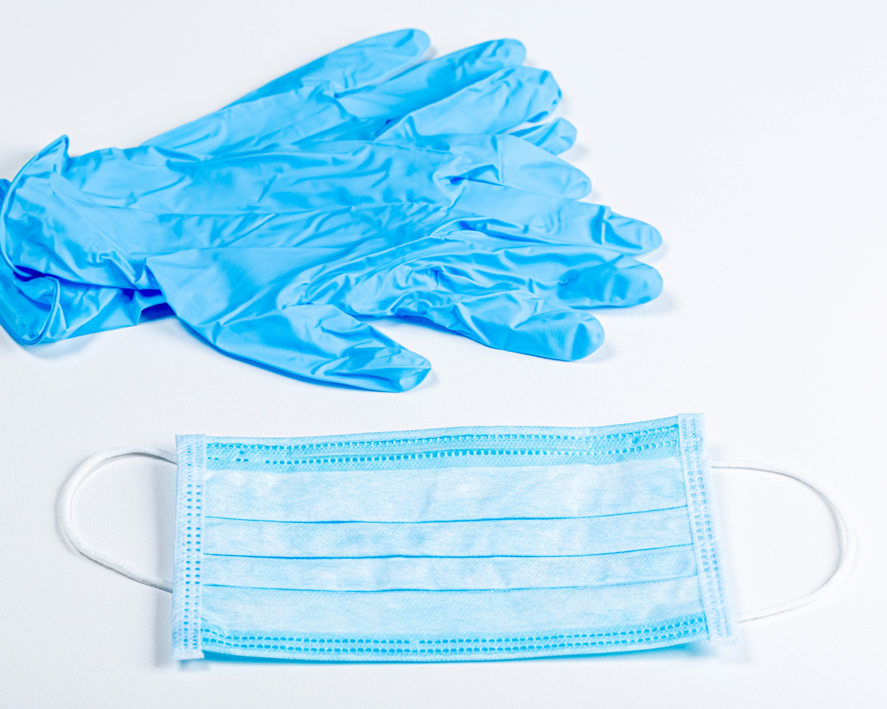 Blue gloves and face mask on a white background from coronavirus