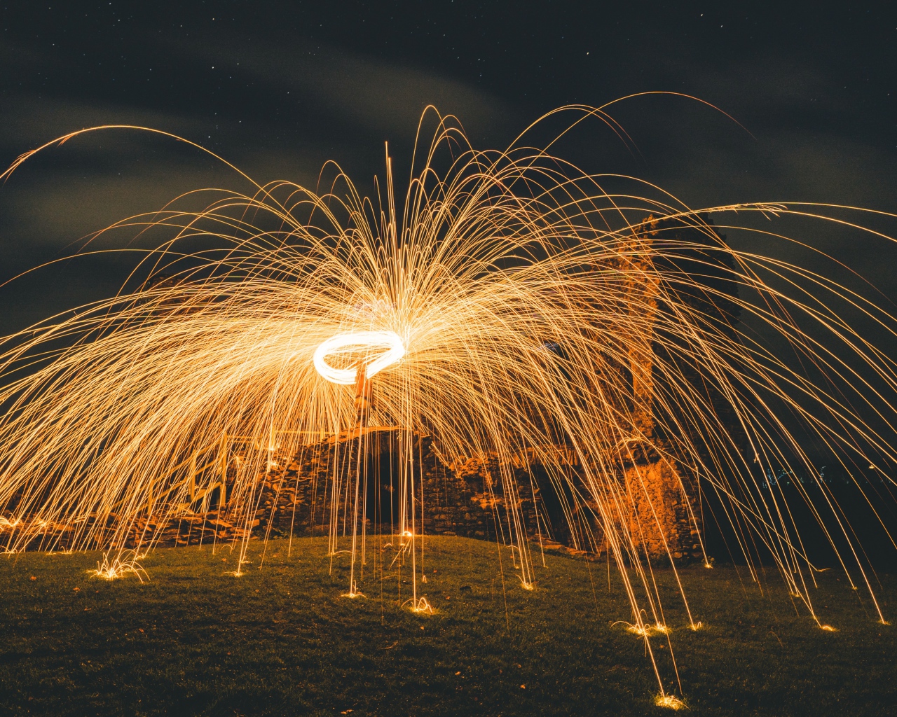 Яркие огненные искры фейерверка на развалинах