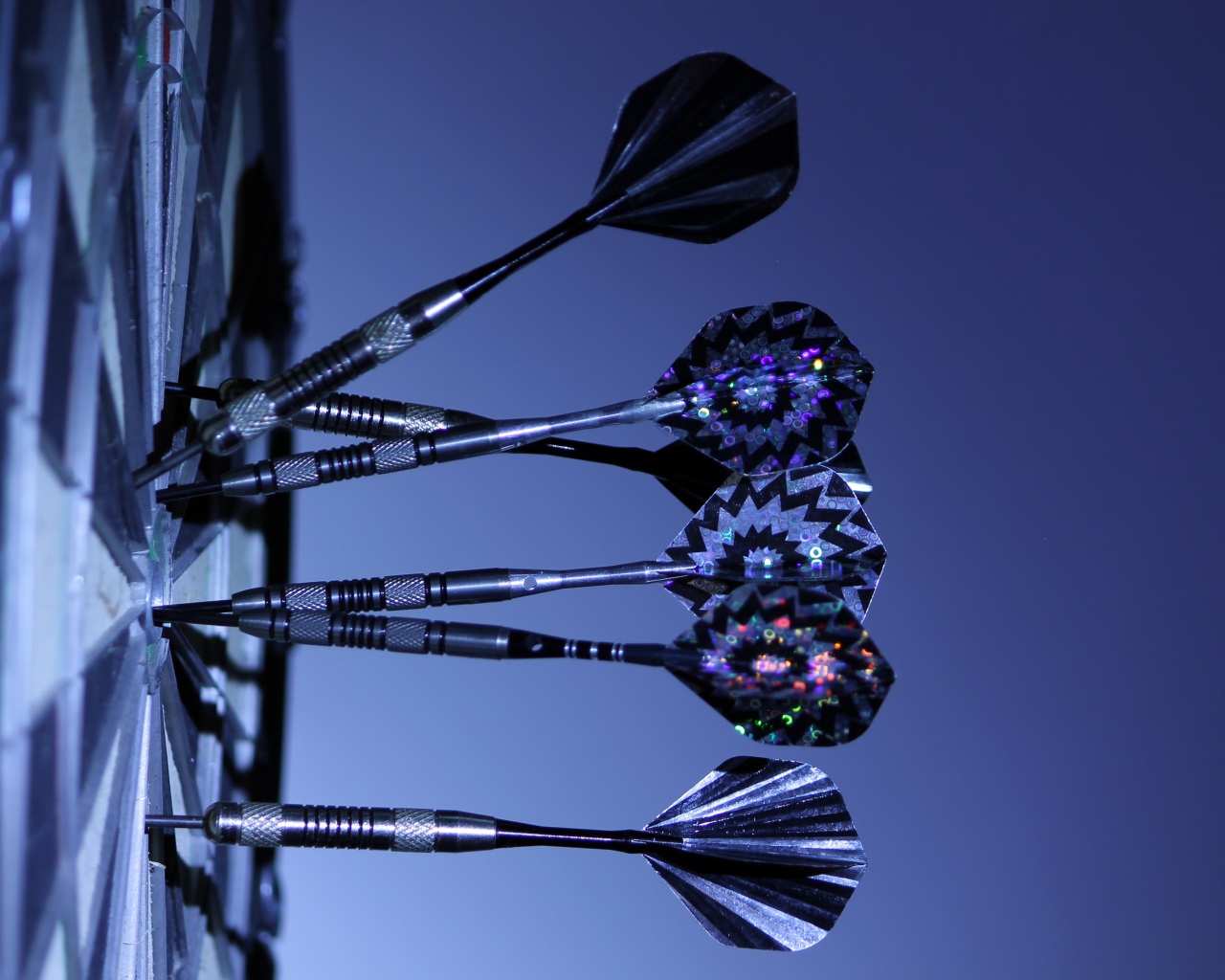 Дротики в доске для дартс на синем фоне 