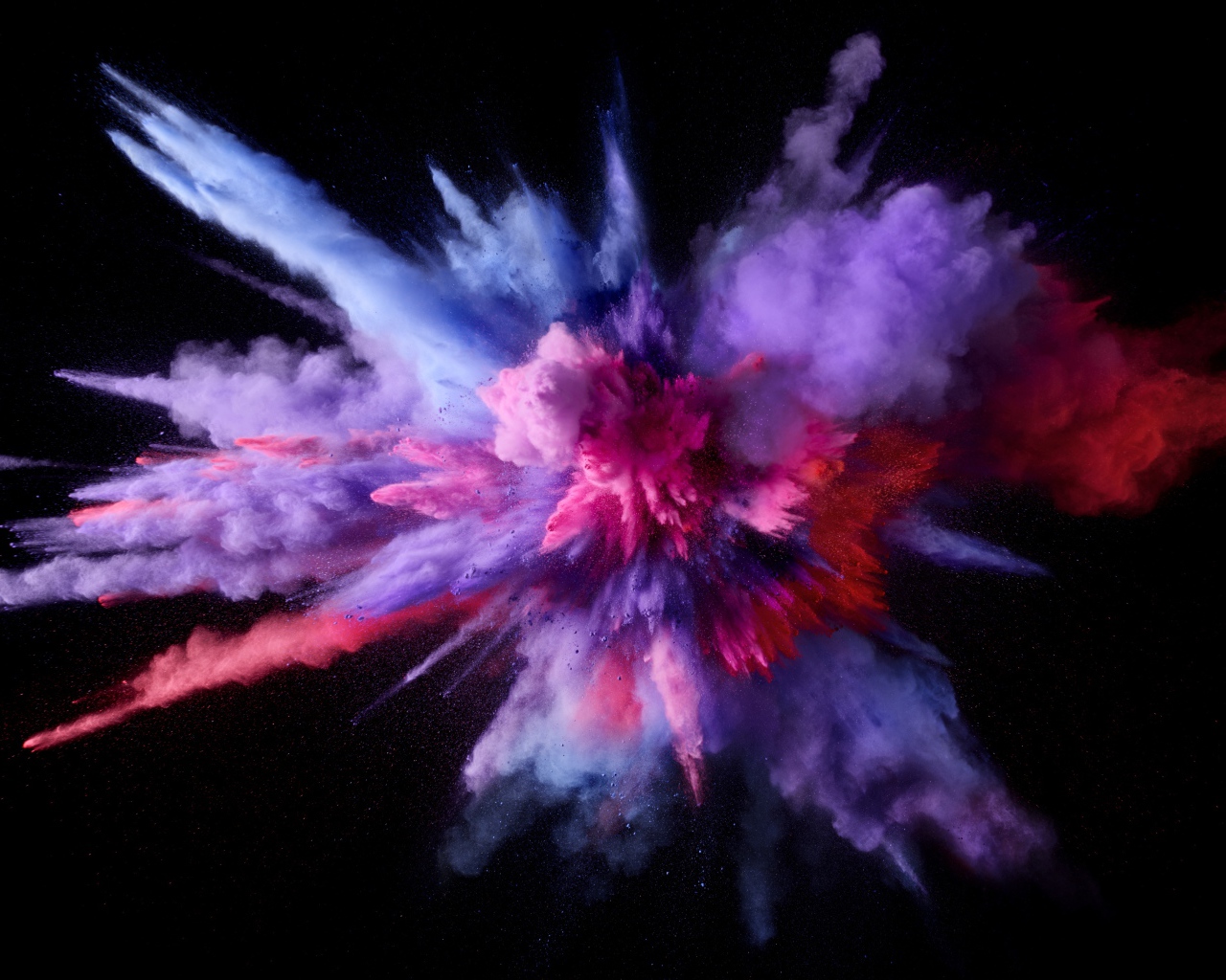 Взрыв разноцветного дыма на черном фоне