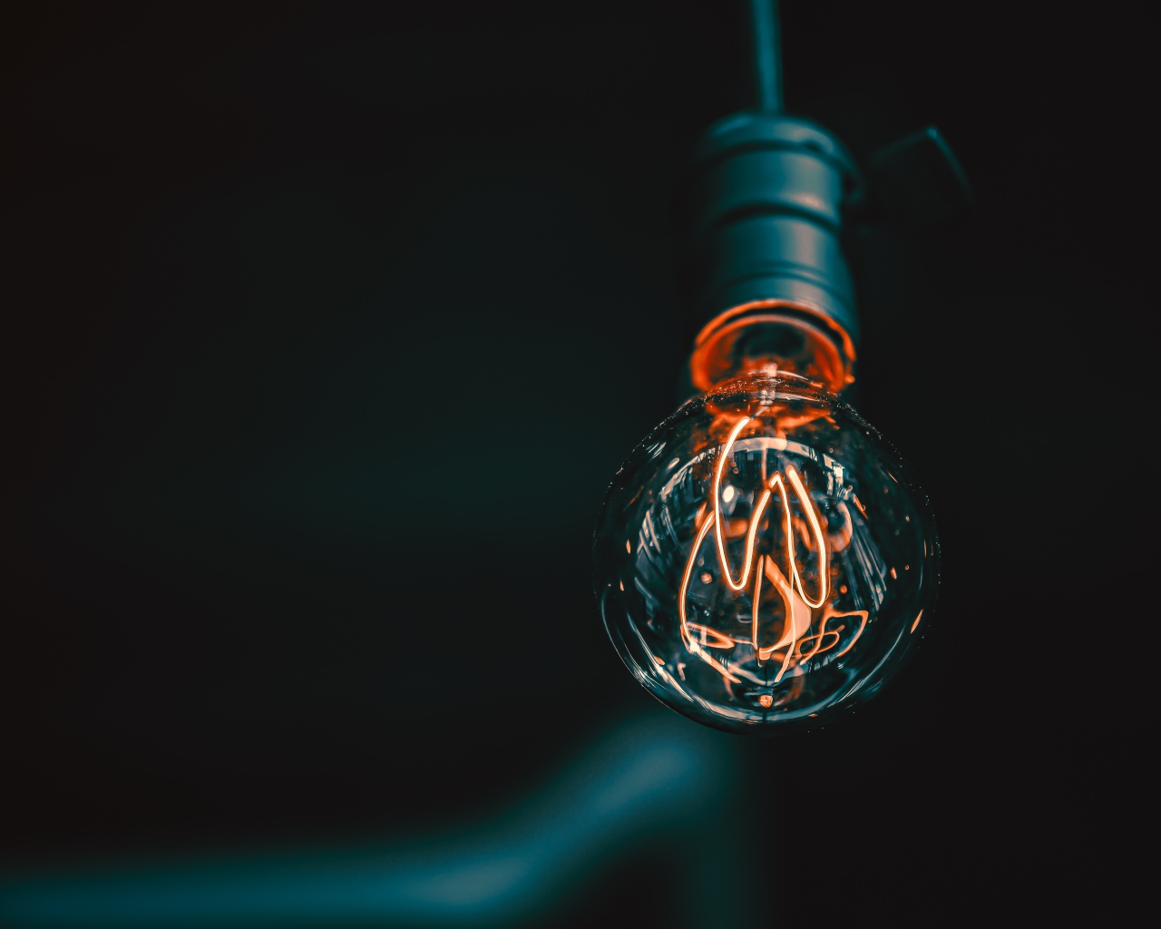 Зажженная лампа накаливания под потолком