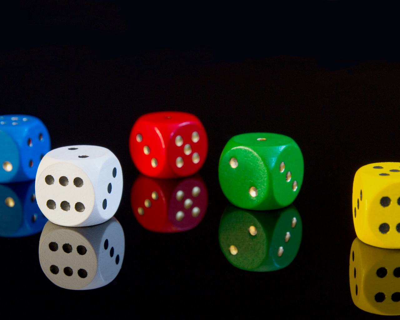 Разноцветные игральные кубики на черном фоне