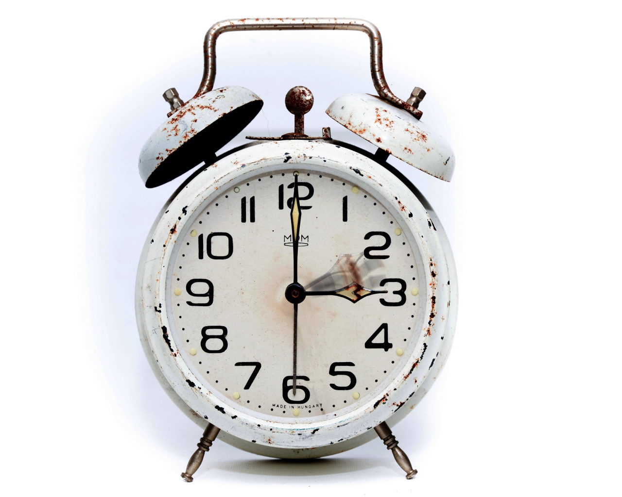 Старый потертый будильник на белом фоне