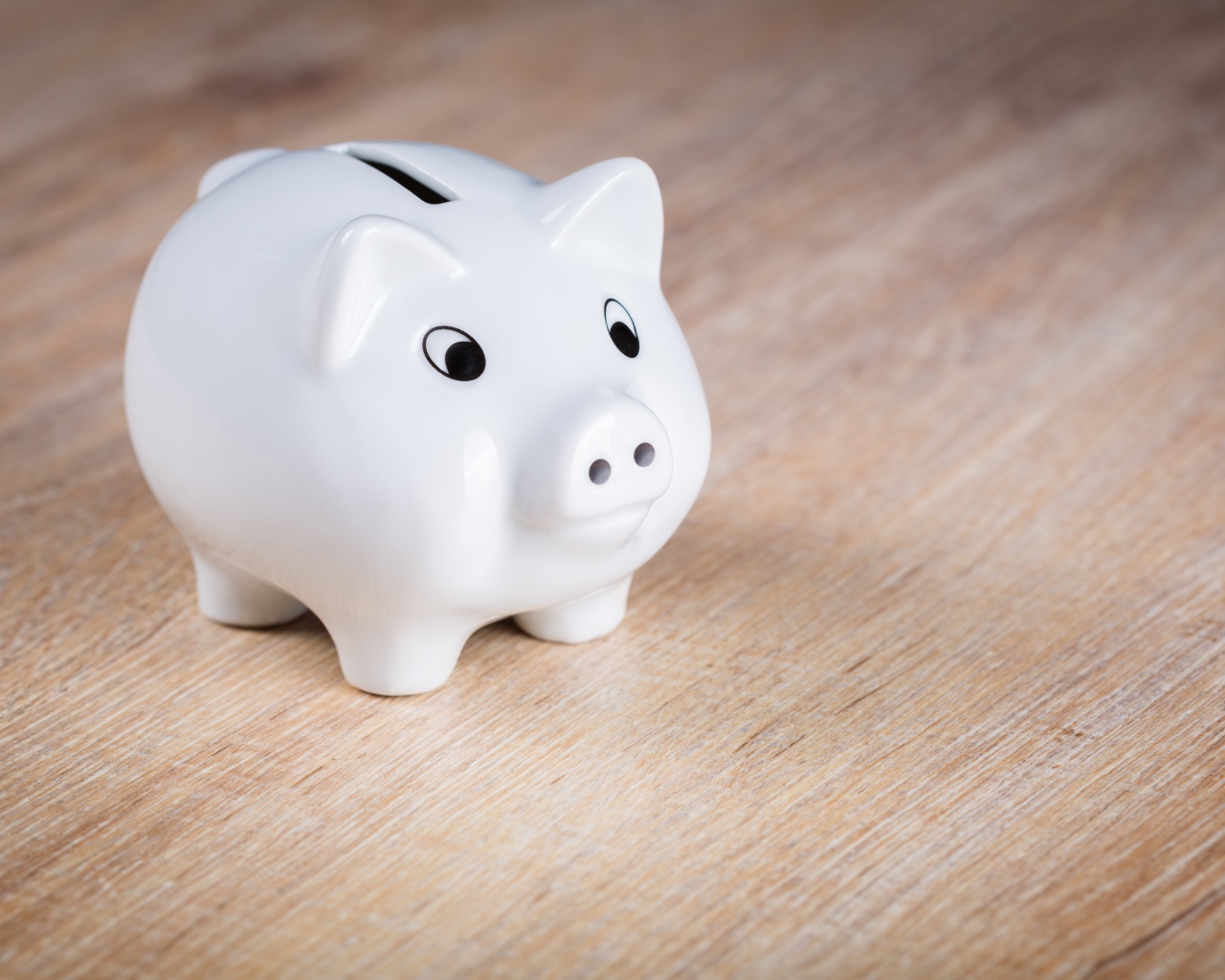 Белая свинья копилка на столе 
