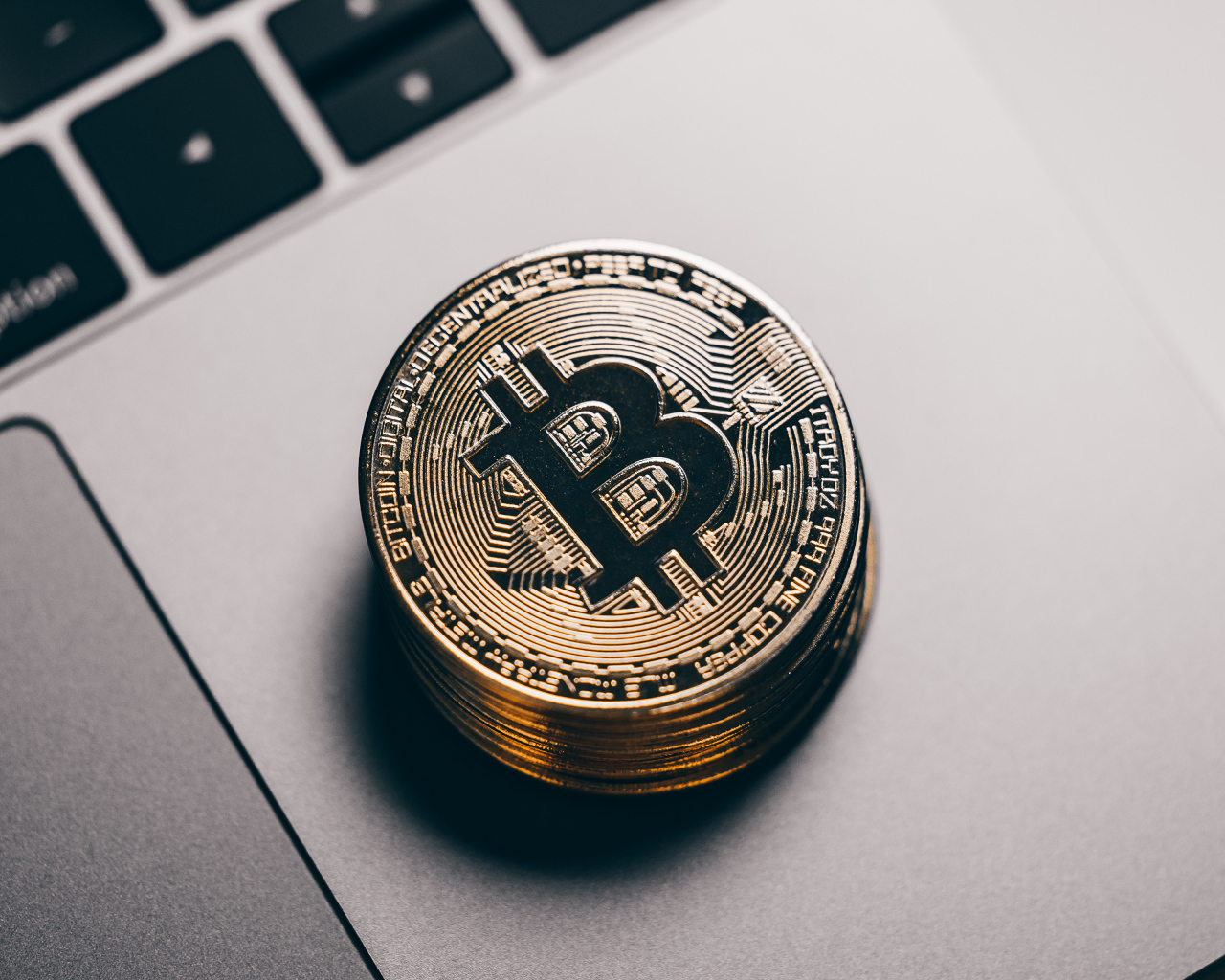 Bitcoin coins lie on a laptop