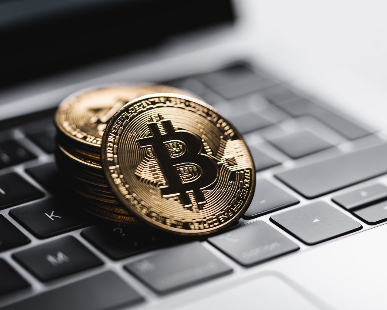 Bitcoin coins lie on a laptop keyboard