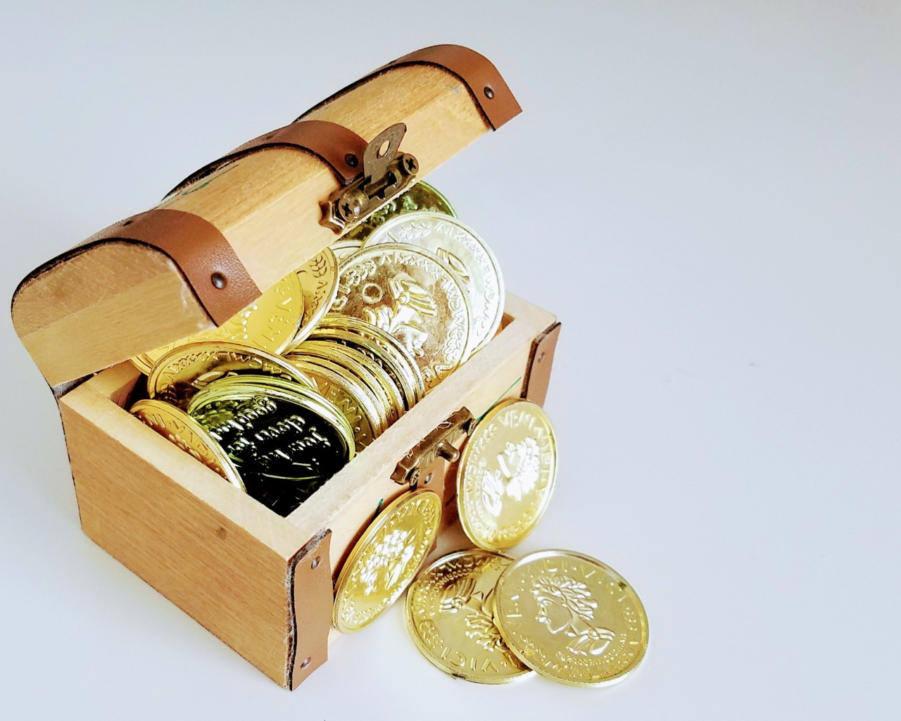 Gold coins in a chest on a gray background