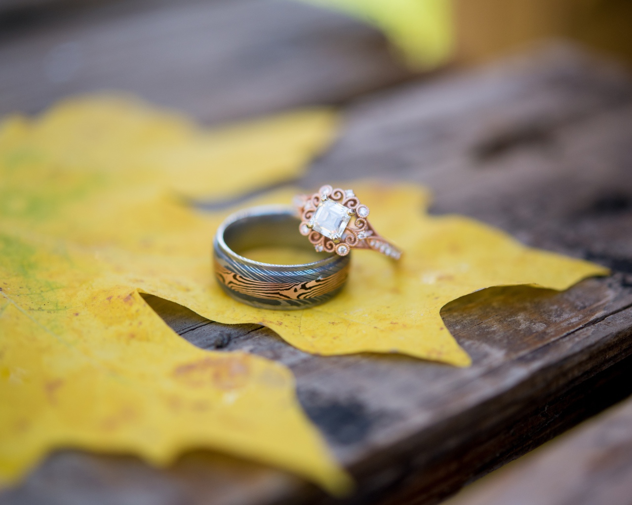 Золотые кольца с желтым листом на столе 