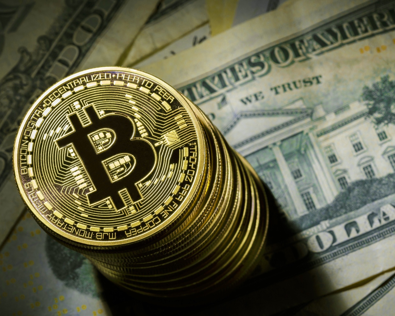 Золотые монеты биткоин лежат на долларах