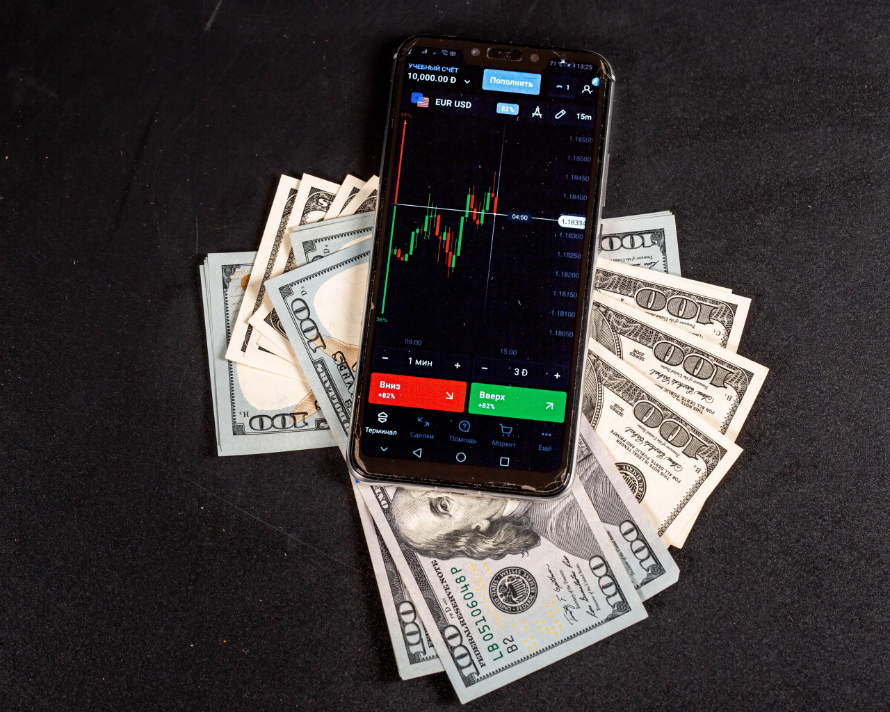 Доллары и смартфон на сером столе 