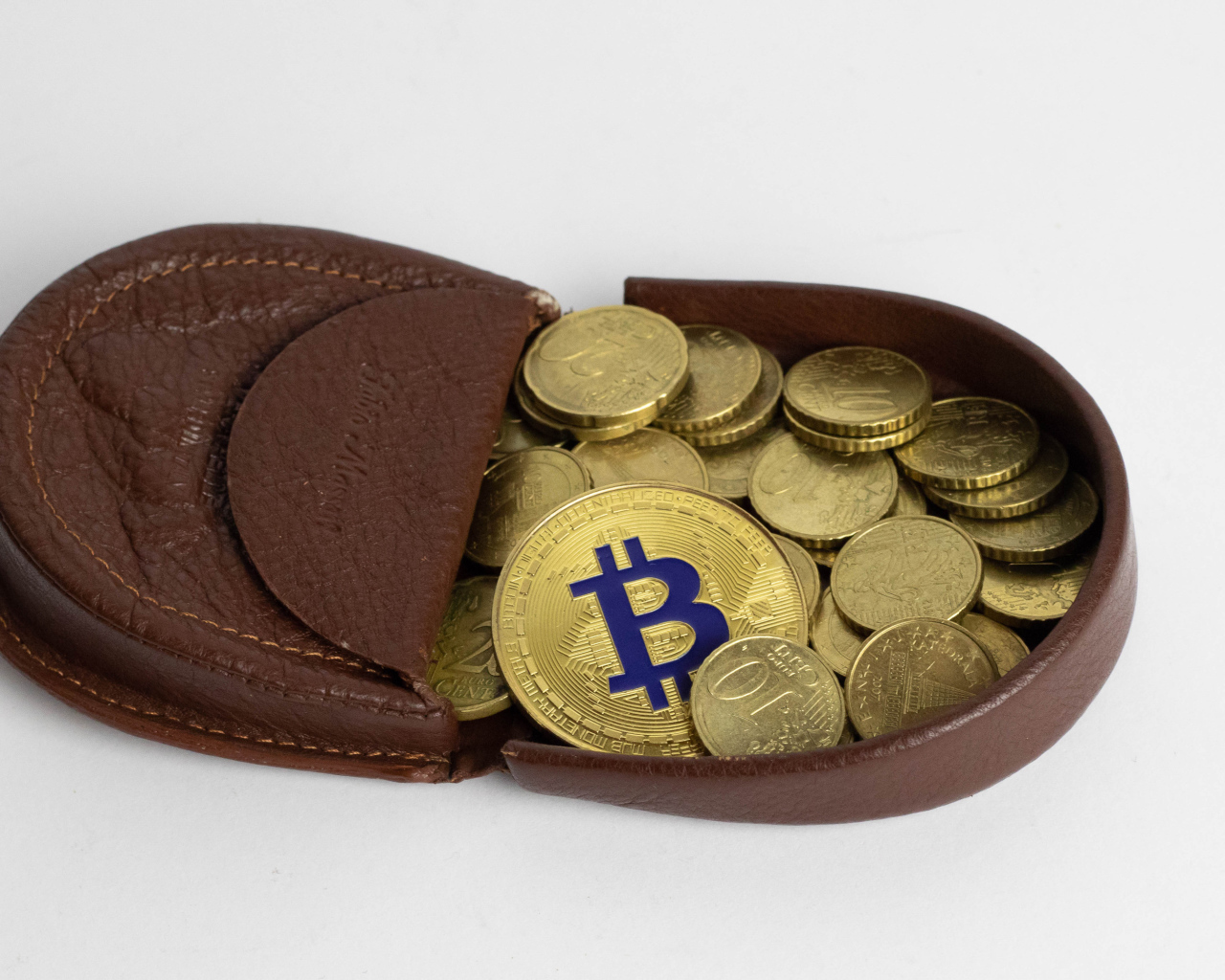 Кожаный кошелек с монетами на сером фоне