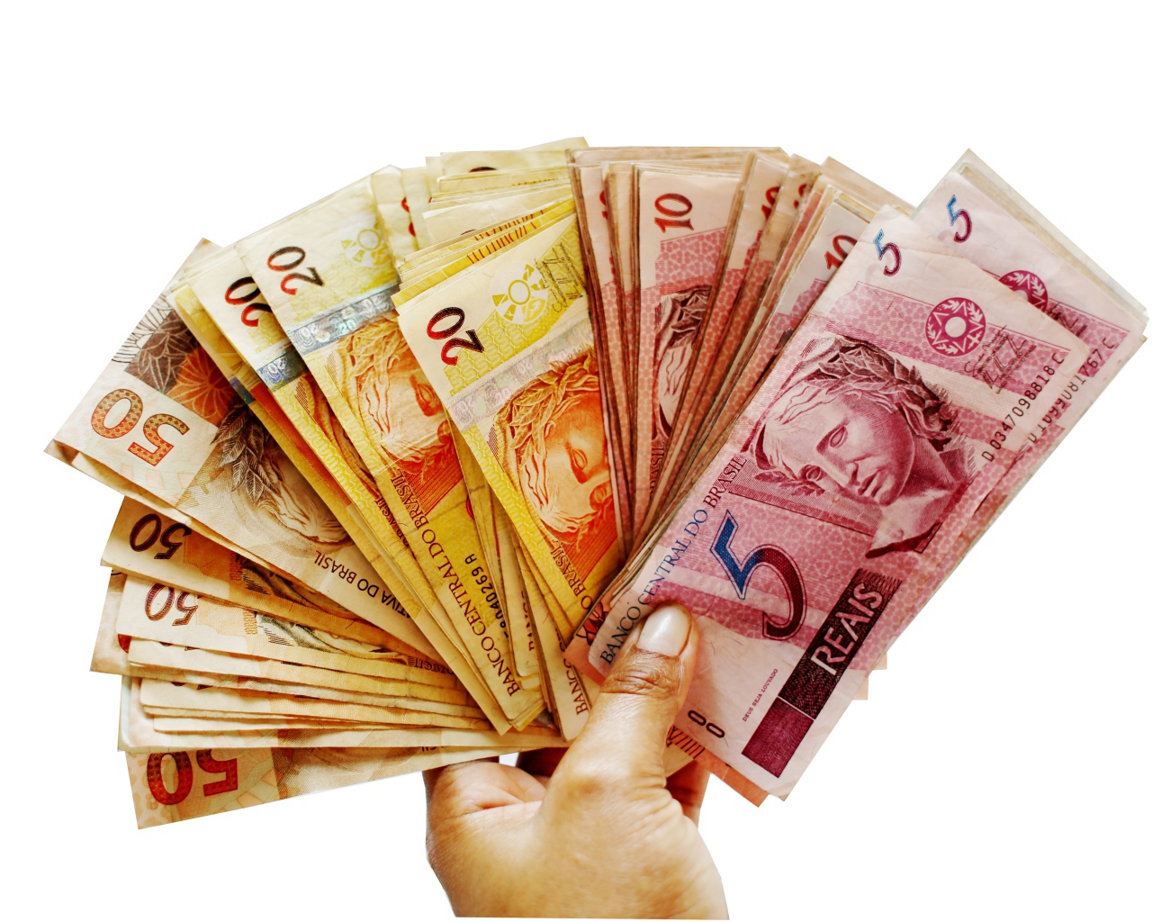 Много купюр бразильского реала в руке на белом фоне 