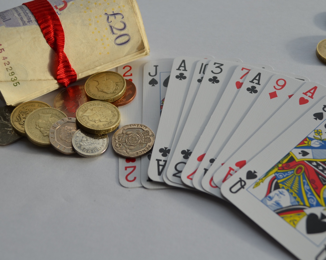 Деньги, монеты и колода карт на столе