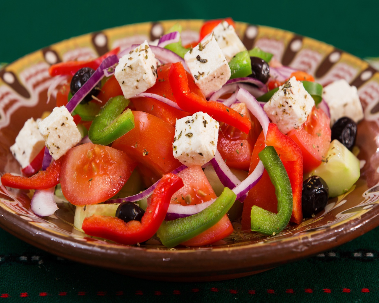 Аппетитный греческий салат в тарелке на столе