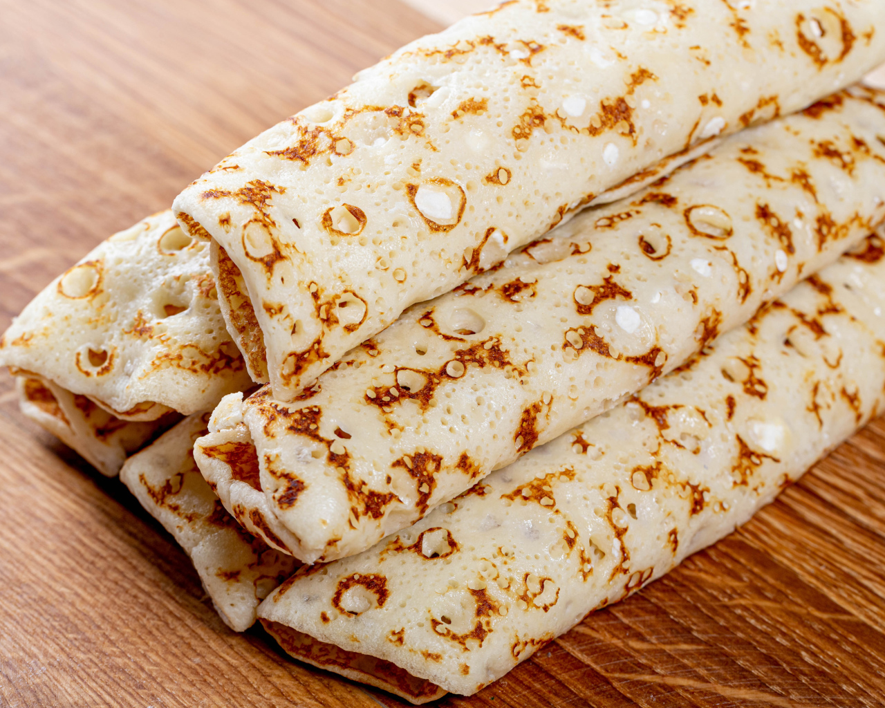 Аппетитные блины на деревянном столе 