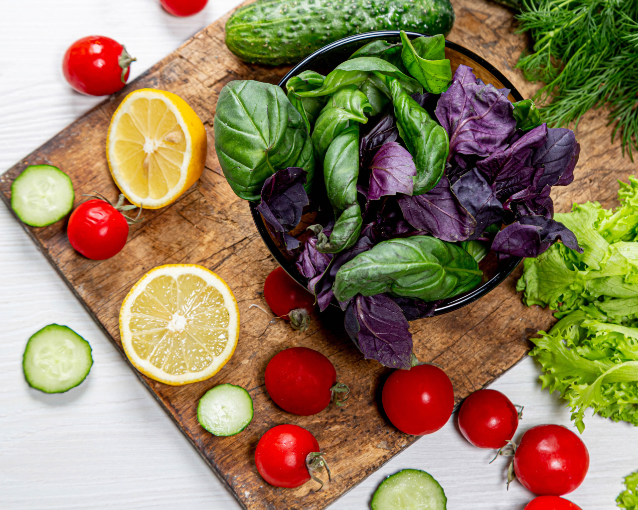 Базилик на столе с зеленью, помидорами и лимоном