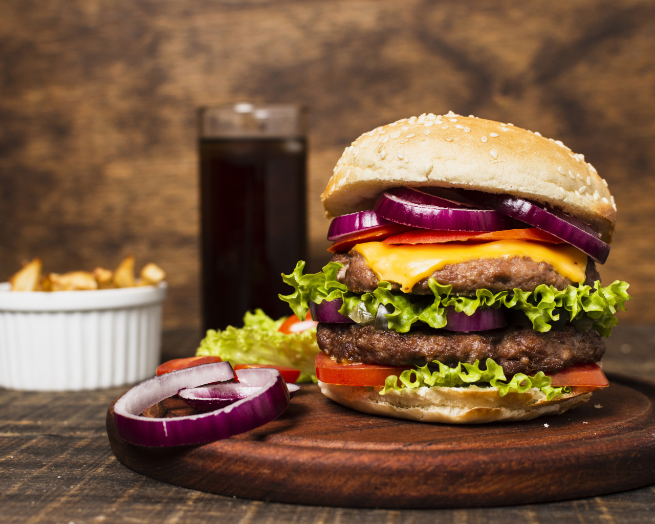 Большой гамбургер на столе с колой и картофелем фри 