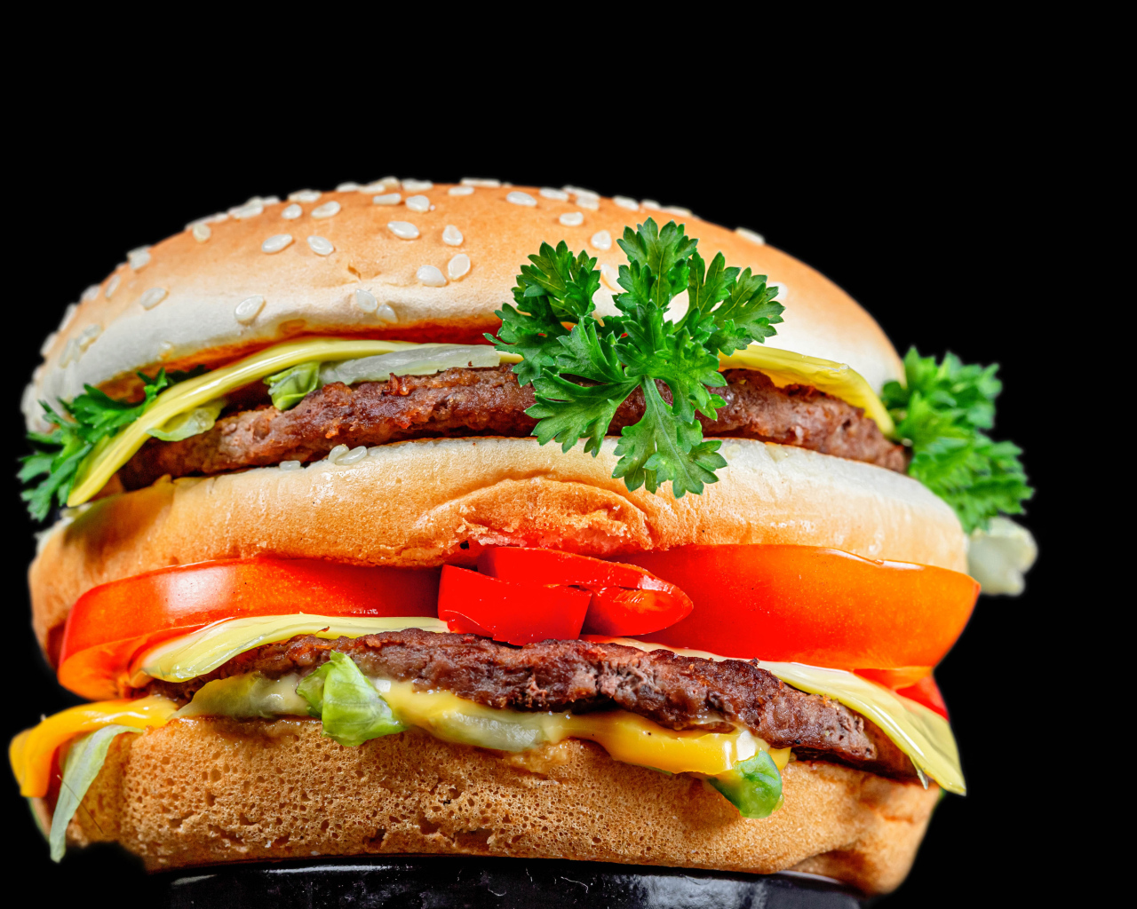 Большой гамбургер с котлетой на черном фоне