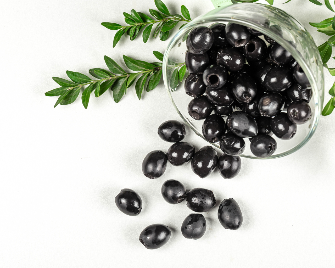 Black olives with rosemary on white background
