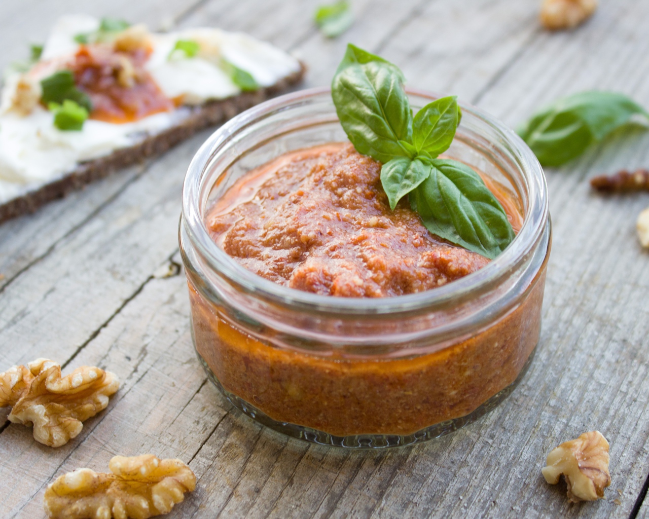 Икра в банке с базиликом на столе с орехами 