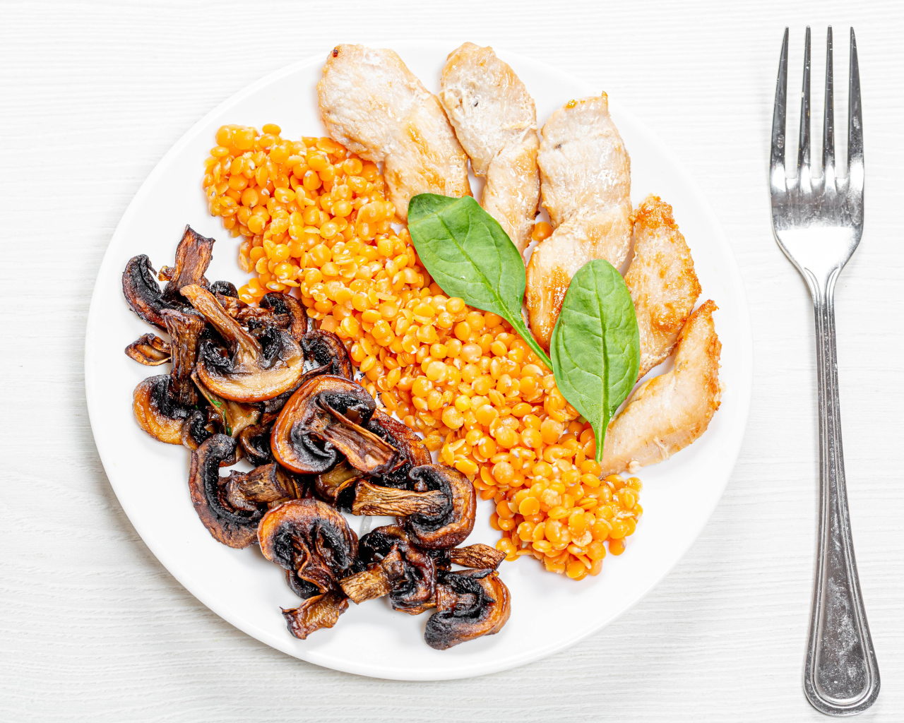 Шампиньоны на тарелке с чечевицей и курицей