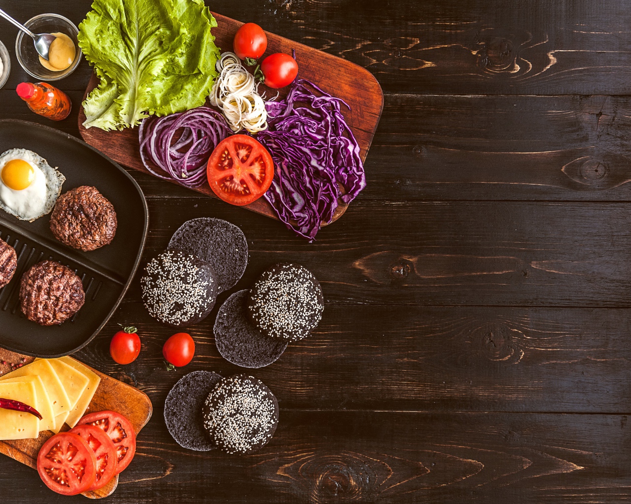 Повар готовит гамбургеры на деревянном столе