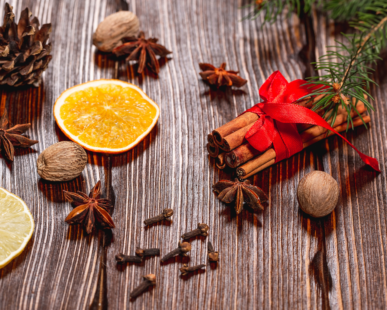 Корица на столе с орехами, бадьяном, сушеными апельсинами и гвоздикой